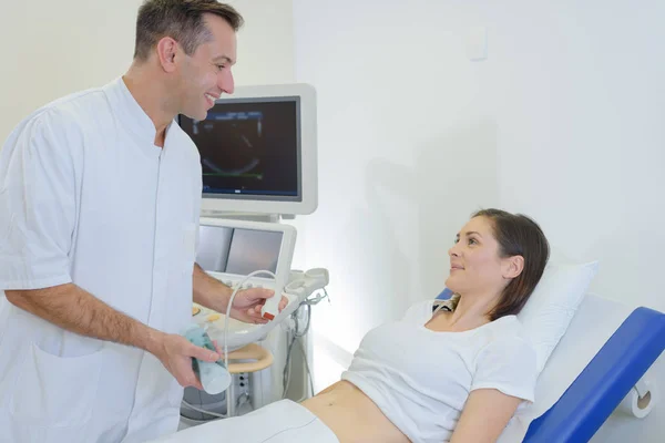 Dottore che fa ultrasuoni sulla pancia della donna incinta in clinica — Foto Stock