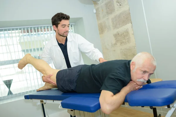 Chiropractor werkt op patiënt been — Stockfoto