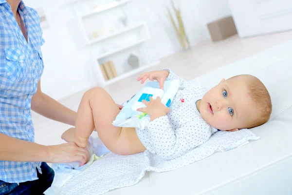 Woman changing a babys diaper — Stock Photo, Image