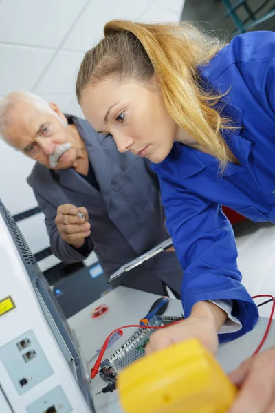 メンターを持つ若い女性電気技師は — ストック写真