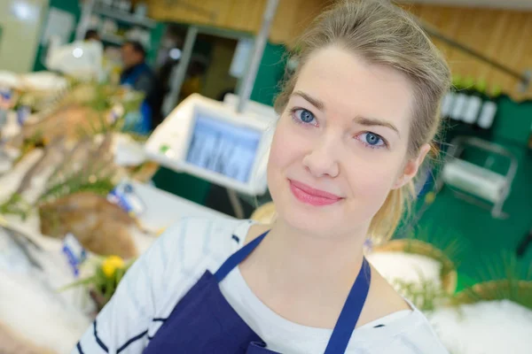 Retrato de assistente de loja feminina positiva vendendo peixe fresco — Fotografia de Stock