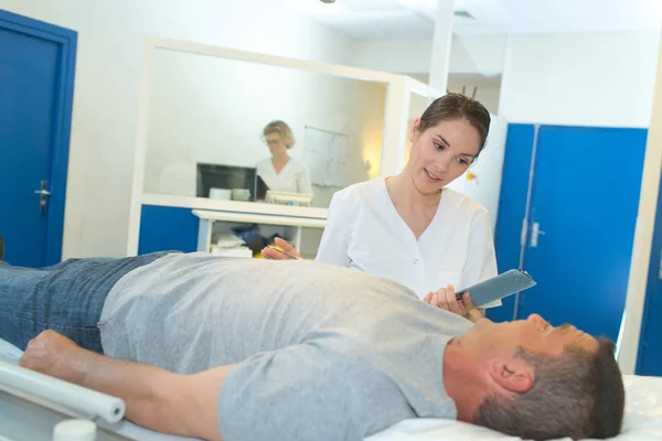 Beautiful nurse visiting mature patient laying in hospital bed — Stock Photo, Image