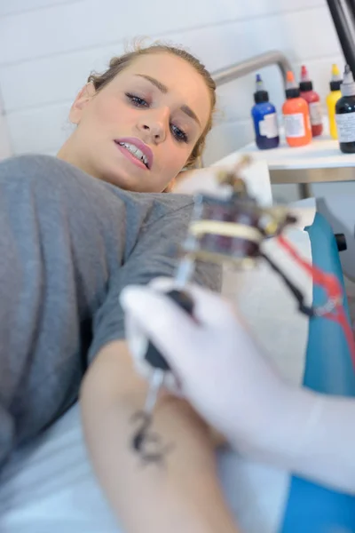 Майстер робить татуювання на жіночому тілі крупним планом — стокове фото