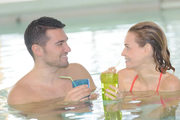 Pareja bebiendo un cóctel en una piscina —  Fotos de Stock