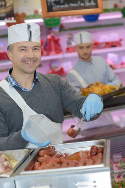 Retrato de homem servindo salsichas cozidas — Fotografia de Stock