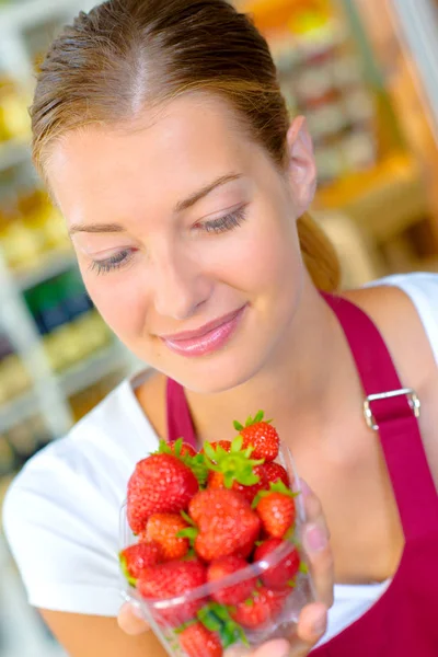 Vrouw kijken naar aardbeien — Stockfoto