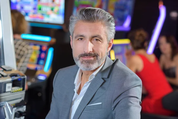 Stilig ung man med spelmaskin i casinot — Stockfoto