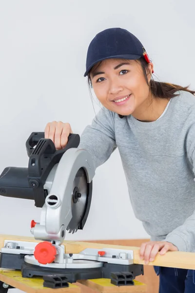 Jovem carpinteiro feminino usando uma serra circular — Fotografia de Stock