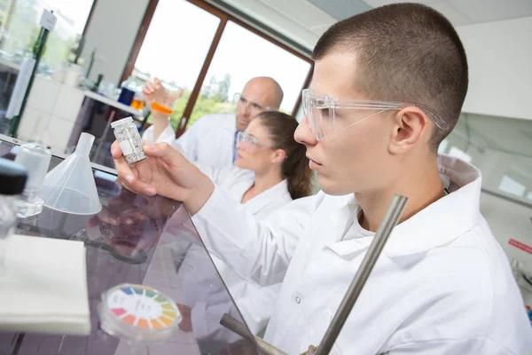 Giovani scienziati attraenti e il loro supervisore in laboratorio — Foto Stock