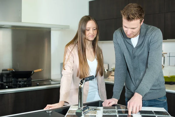 Gelukkige jonge paar nieuwe keuken in de winkel kopen — Stockfoto