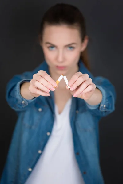 Νεαρή γυναίκα είναι το σπάσιμο ένα τσιγάρο — Φωτογραφία Αρχείου
