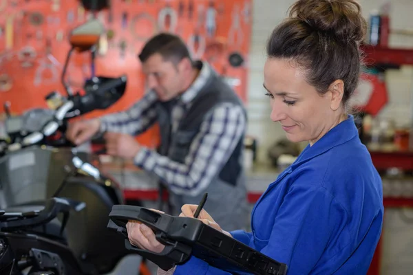 Riparazione moto femminile in un garage — Foto Stock