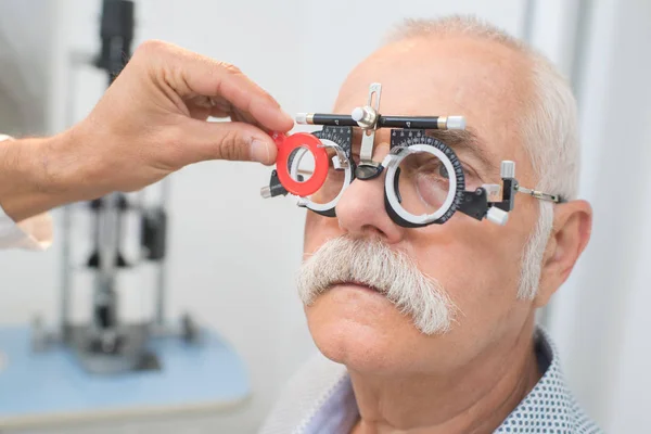 Eye specialist determines distance of eyes pupils to patient — Stock Photo, Image