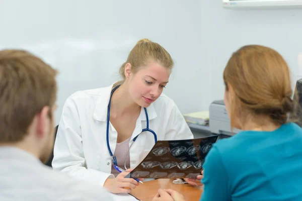 Dentista femenina mostrando radiografía de dientes a paciente en clínica — Foto de Stock