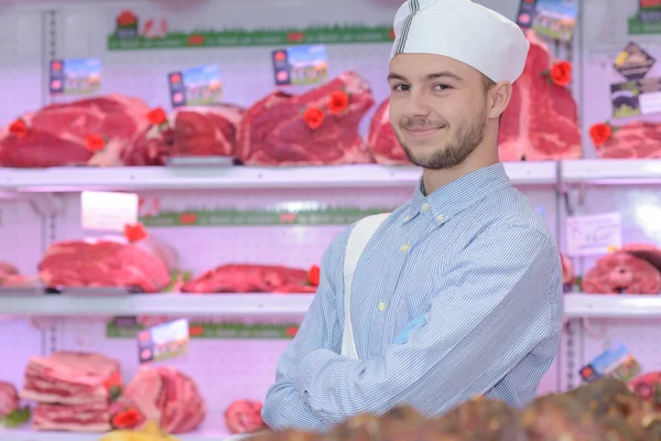 Jovem açougueiro posando e trabalho — Fotografia de Stock