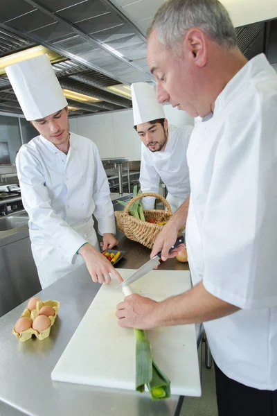 Équipe de jeunes apprentis chefs préparant des plats de charcuterie — Photo