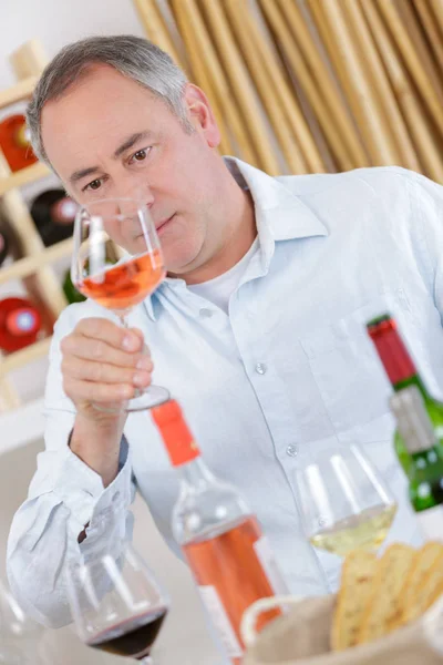 Knappe volwassen man glas rose wijn proeverij — Stockfoto