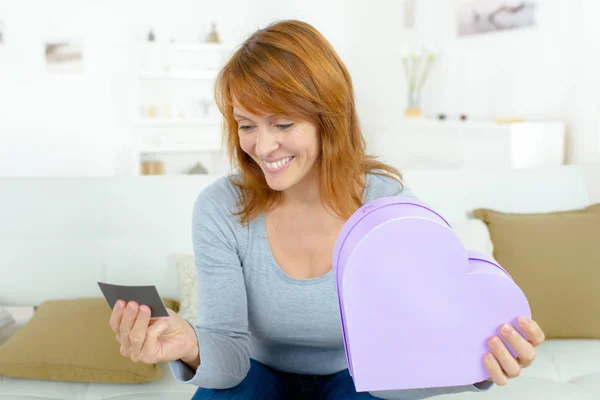 Mooie vrouw met Valentijnsdag geschenk in hartvormige doos — Stockfoto