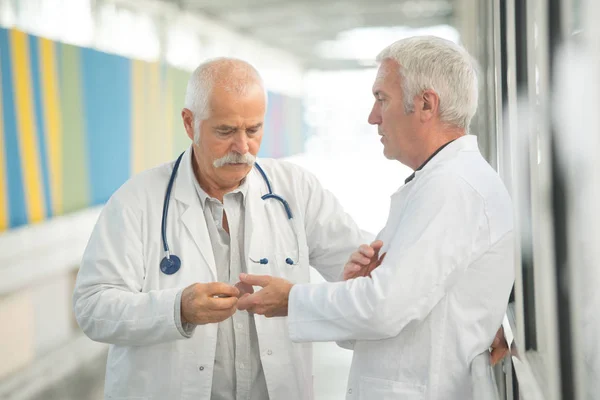 Doctor passing object to colleague — Stock Photo, Image