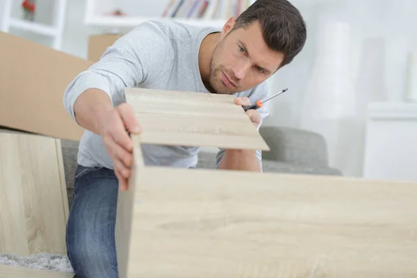 Homem montando prateleira em casa — Fotografia de Stock