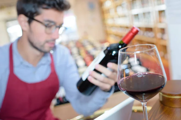 Copa de vino con vendedor de licorería en el fondo —  Fotos de Stock