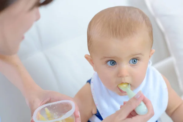 Mamma mata hennes pojke med en sked — Stockfoto