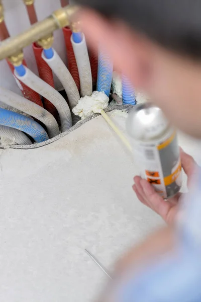 Encanador de espuma pulverização em torno de tubos — Fotografia de Stock
