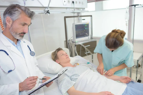 Porträtt av sjuksköterska läkare och kvinnlig patient i sängen — Stockfoto