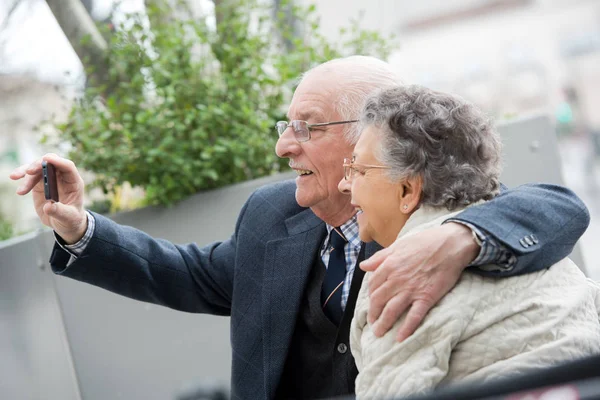 Coppia anziana gioiosa prendendo selfie — Foto Stock
