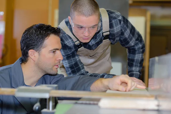 Ung lärling med lärare som arbetar på träbiten — Stockfoto