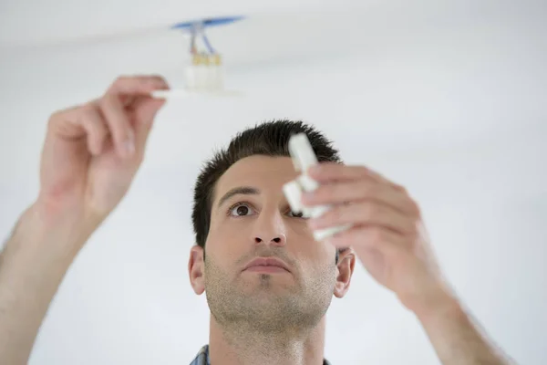 Man fitting light to ceiling — Stock Photo, Image