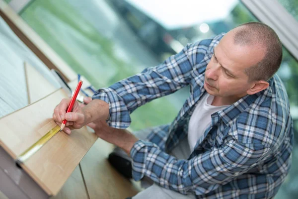 Férfi carpenter fa ceruza telephelyén dolgozik — Stock Fotó