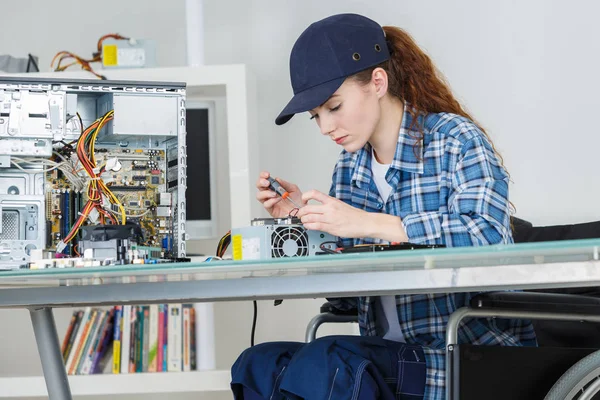 Молода усміхнена брюнетка технік ремонтує комп'ютер — стокове фото