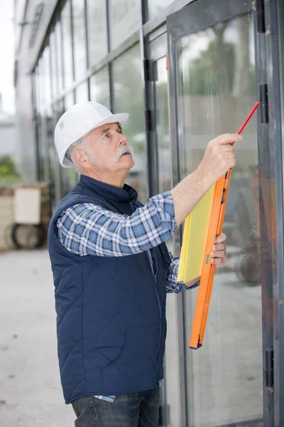 Operaio edile senior con livello di spirito — Foto Stock