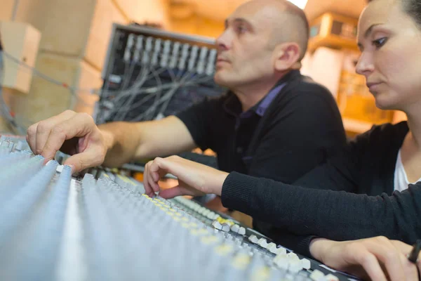 Pareja trabajando en un panel de control del mezclador de sonido —  Fotos de Stock