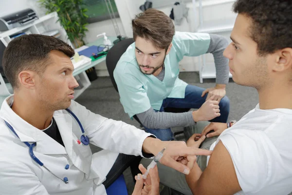 Médico segurando uma seringa com um líquido — Fotografia de Stock