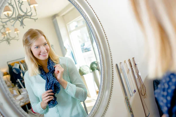 Mulher verificando sua aparência em um espelho — Fotografia de Stock