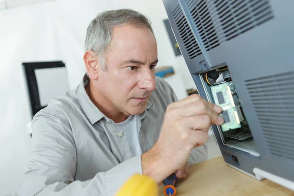 Tecnico senior che lavora su apparecchi elettrici — Foto Stock