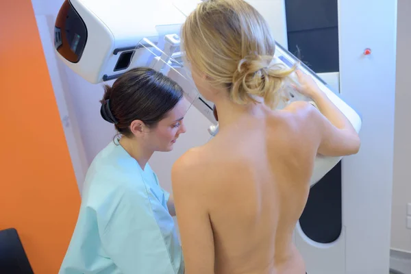Жінка, що має мамографію і пацієнта — стокове фото