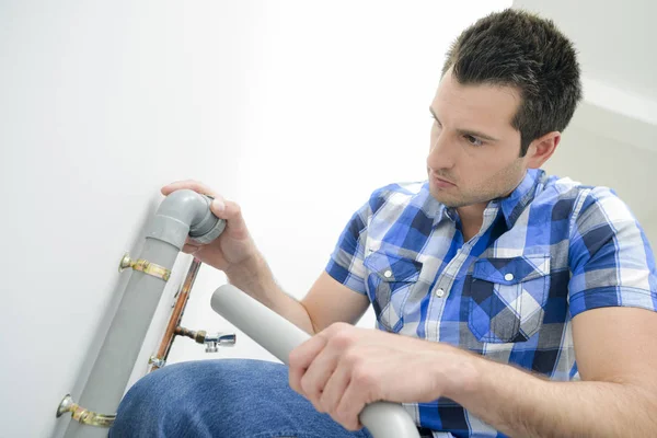 Plumber with a plastic pipe — Stock Photo, Image