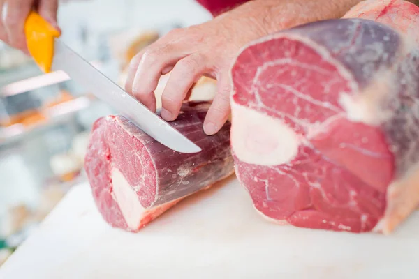 Butcher slicing meat and agriculture — Stock Photo, Image