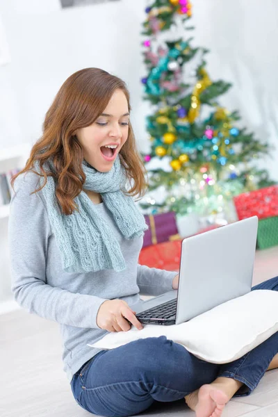 Gelukkige vrouw met laptop in de woonkamer en kerstboom — Stockfoto