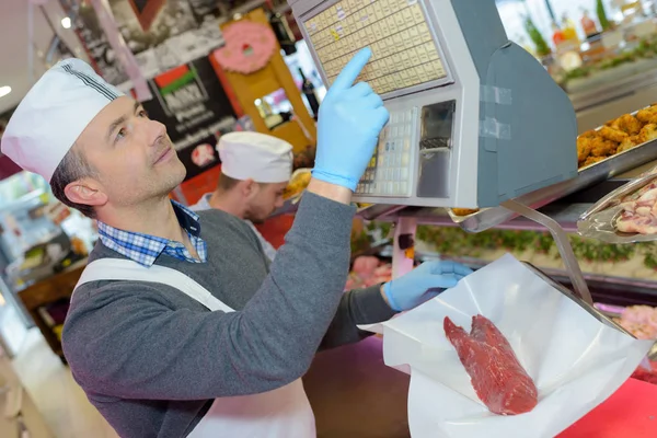 Metzger wägt Stück Steak ab — Stockfoto