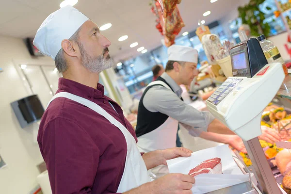 Slager vlees serveren en slager — Stockfoto