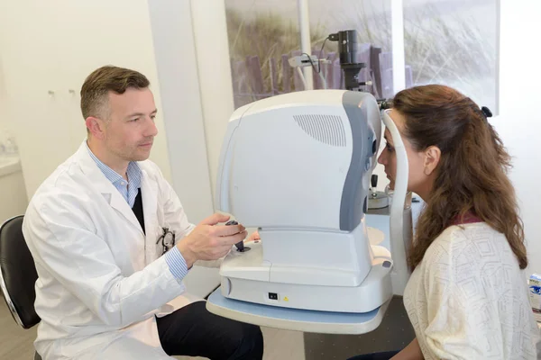 Göz testi makinede göz doktoruna bakarak kadın — Stok fotoğraf