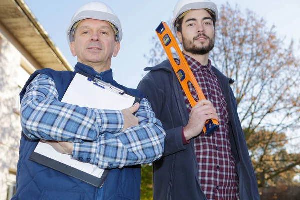 Construtores sorridentes em hardhats ao ar livre — Fotografia de Stock