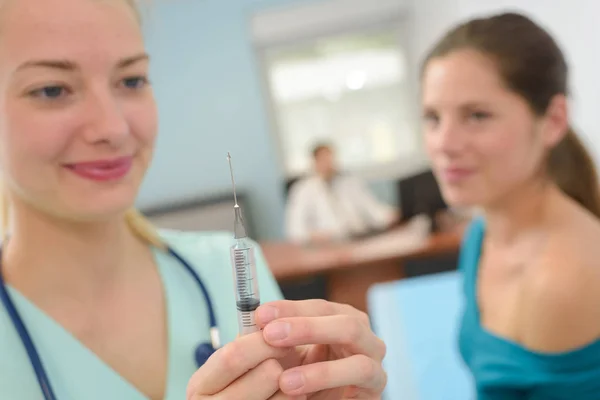 Krankenschwester bereitet Spritze für Patientin vor — Stockfoto