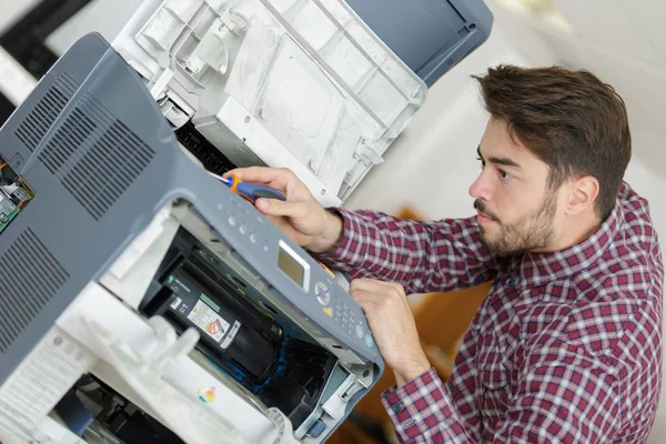 Sostener un destornillador para fijar la impresora — Foto de Stock