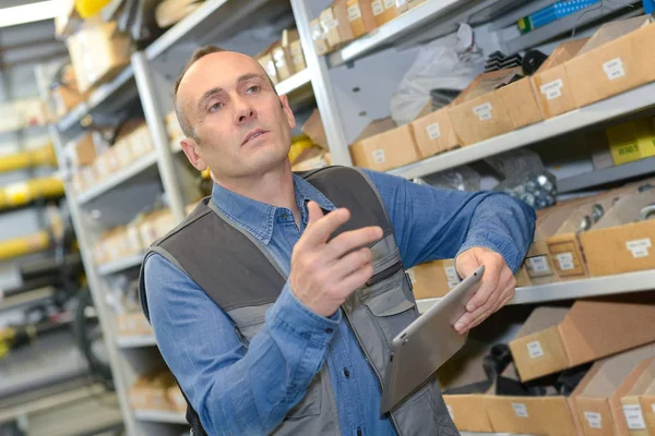 Trabajador manual con tableta pc en el almacén — Foto de Stock