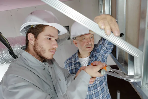 Constructeurs installant le panneau isolant structurel de maison de cadre — Photo